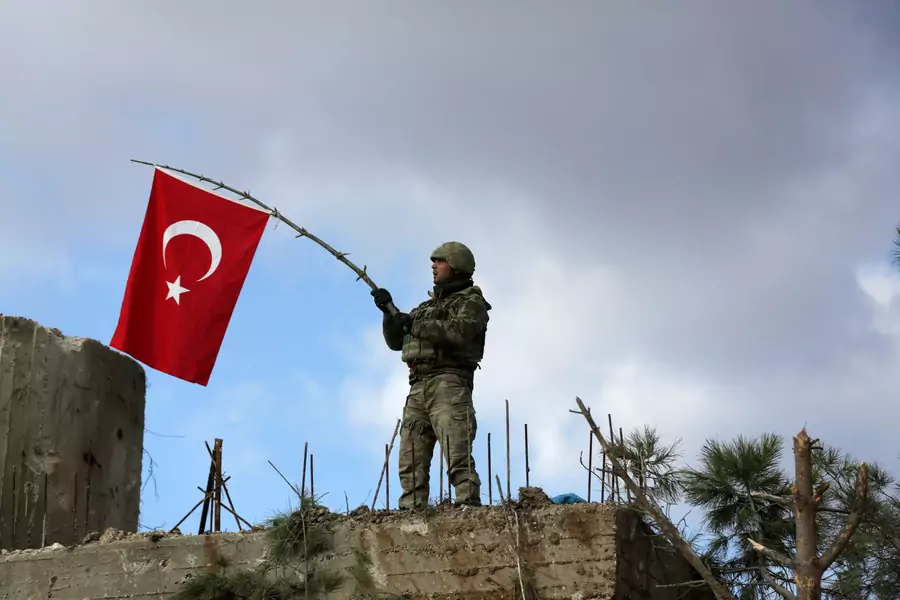 A Turkish soldier waves a flag on Mount Barsaya, northeast of Afrin, Syria January 28 ,2018. 