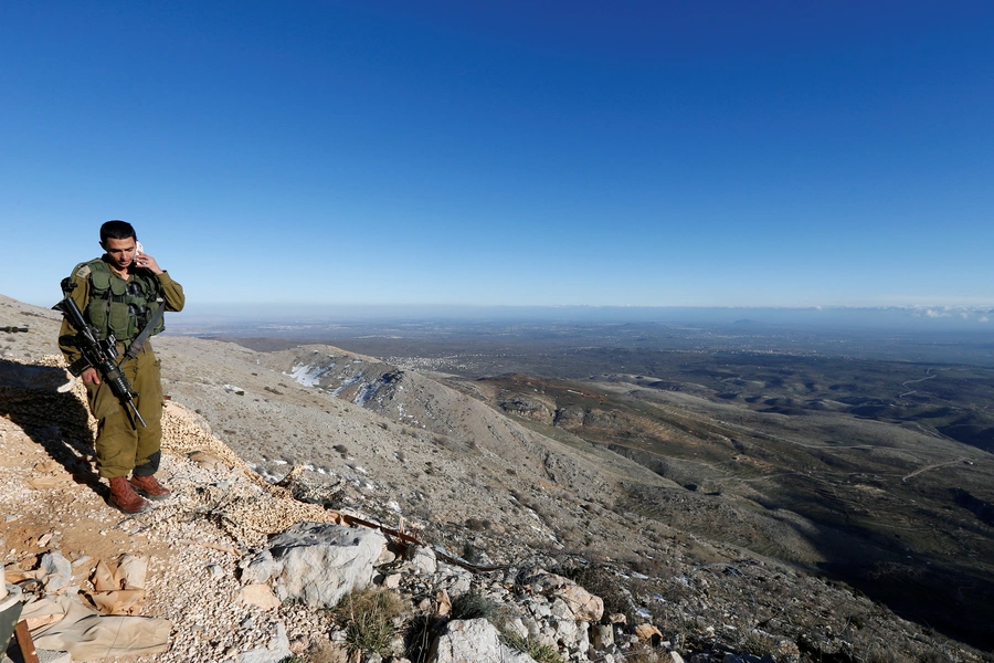 An Israeli soldier speaks on his mobile phone at a military outpost on Mount Hermon in the Golan Heights over looking the Israel-Syria border February 4, 2015.