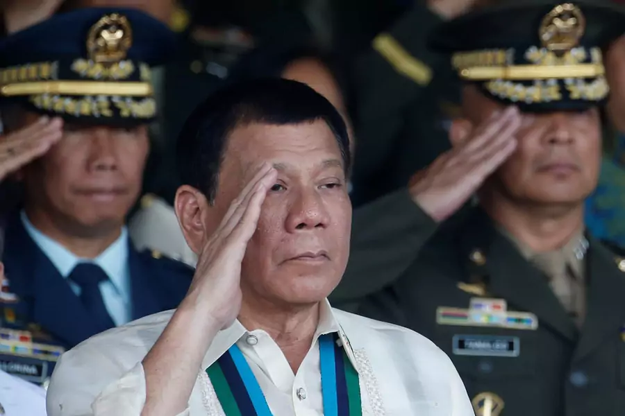 Philippine President Rodrigo Duterte salutes with other military officers during a anniversary celebration of the Armed Forces at a military camp in Quezon city, Metro Manila on December 21, 2016.