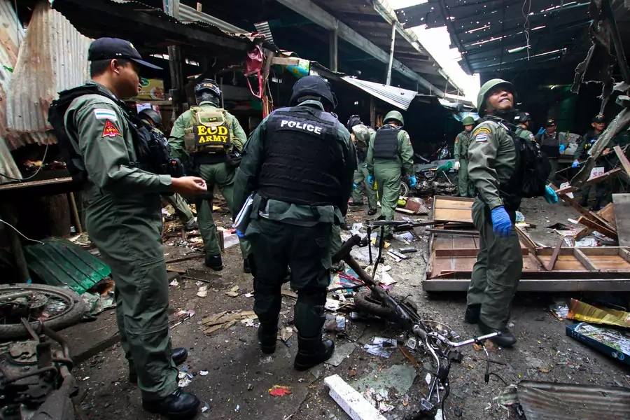 Military personnel and police officers inspect the site of a bomb attack at a market in the southern province of Yala, Thailand, on January 22, 2018. 