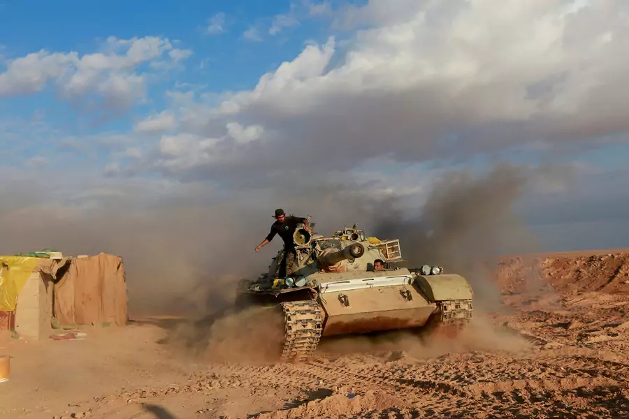 Popular Mobilization Forces fighters ride in a tank near the Iraqi-Syrian border in al-Qaim, Iraq. 