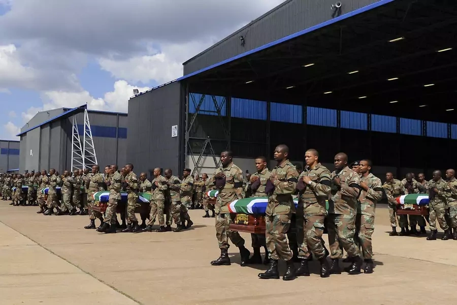 Members of the South Africa National Defense Force (SANDF) carry the remains of 13 members that were killed in Central African Republic (CAR) during the handing over to the respective families at the Waterkloof Air Force Base, Pretoria, on March 28, 2013.