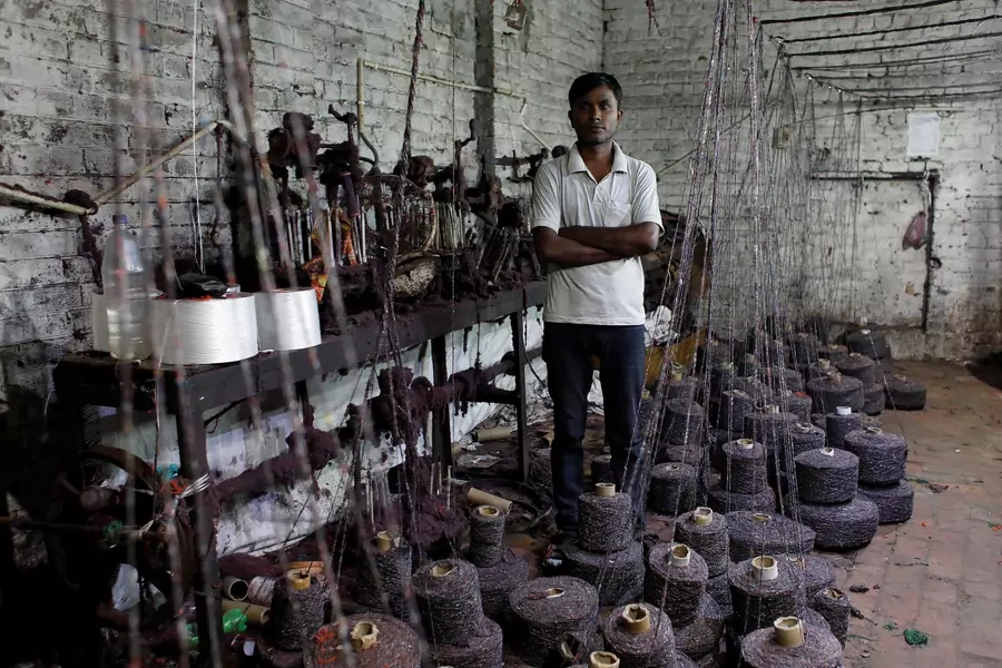 Ram Pratap, who lost his job as a powerloom operator earlier this year, poses for a picture inside a weaving factory where he used to work, in Panipat in the northern state of Haryana, India, 