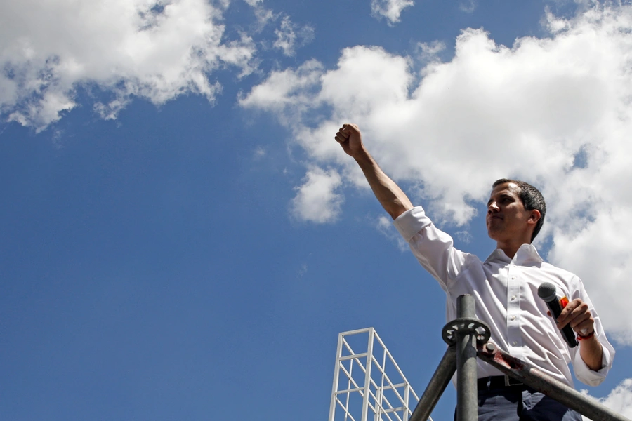 Venezuelan opposition leader Juan Guaido, who many nations have recognized as the country's rightful interim ruler, reacts during a meeting with volunteers to coordinate humanitarian aid in Caracas, Venezuela