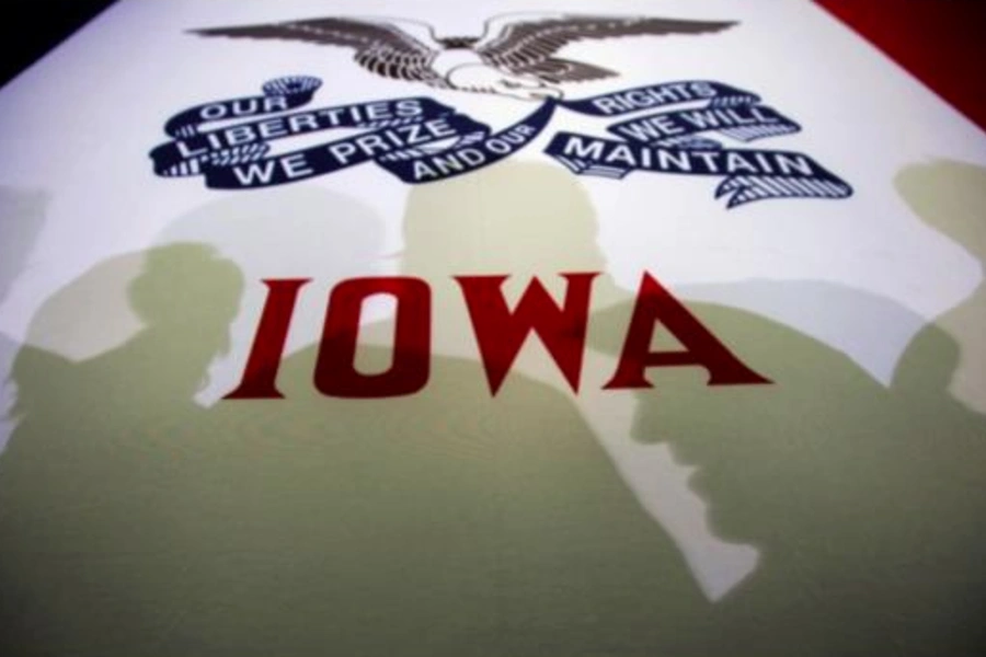 Potential caucus voters cast shadows on an Iowa state flag at a campaign rally in Clive, Iowa, January 2, 2012.