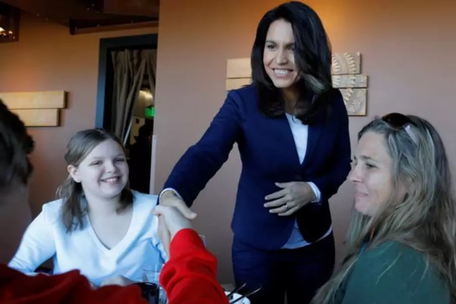 Tulsi Gabbard greets diners during a campaign stop at the Green Elephant in Portsmouth, New Hampshire.