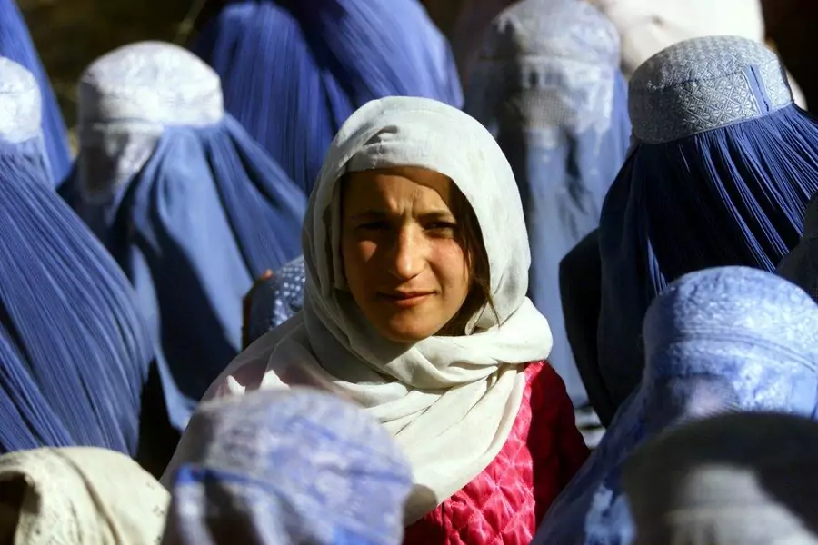 A young Afghan woman shows her face in public for the first time in five years in Kabul, Afghanistan, November 14, 2001.