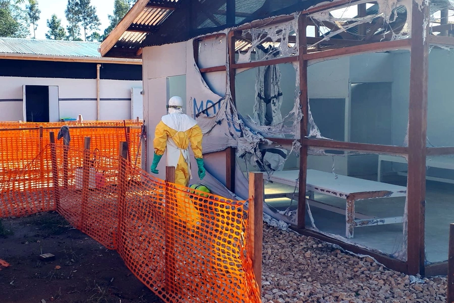 A health worker dressed in a protective suit walks past burned structures after attackers set fire to an Ebola treatment center run by Medecins Sans Frontieres (MSF) in the east Congolese town of Katwa, Democratic Republic of Congo, on February 25, 2019.