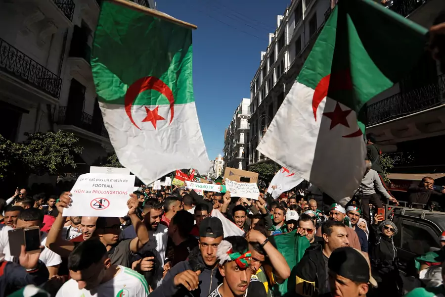 People carry their national flags as they gather during a protest over President Abdelaziz Bouteflika's decision to postpone elections and extend his fourth term in office, in Algiers, Algeria March 15, 2019