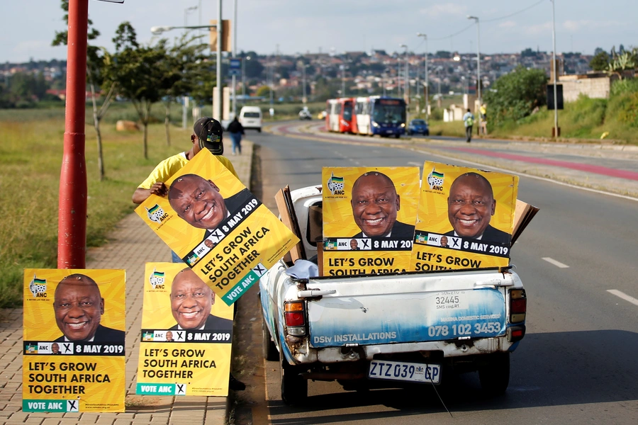 Musa Masina lines up election posters with the face of ANC president Cyril Ramaphosa, before hanging them on street poles in Soweto, South Africa, on March 12, 2019.