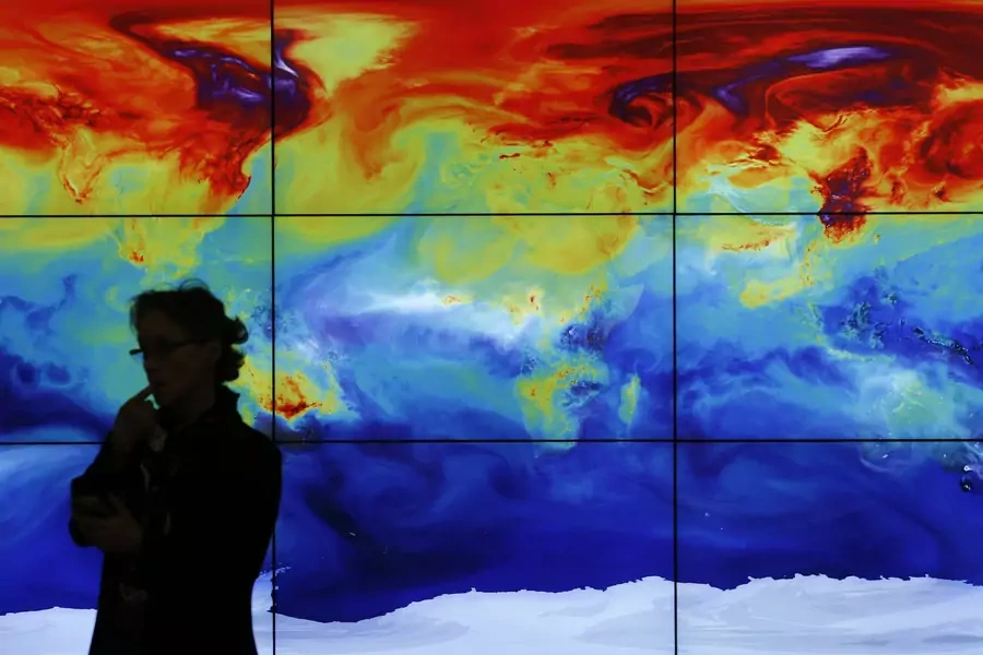 A participant in front of a screen showing a world map during the World Climate Change Conference 2015 (COP21) at Le Bourget, near Paris, France, December 8, 2015.