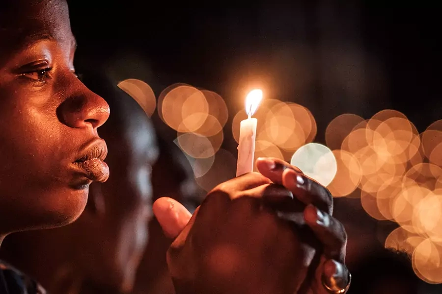 A person holds a candle during a night vigil and prayer at the Amahoro Stadium as part of the 25th commemoration of the 1994 genocide, in Kigali, Rwanda, on April 7, 2019.