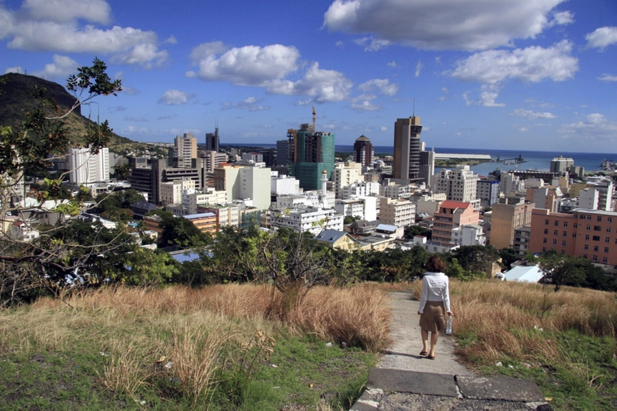 A woman walks down a hill to Port Louis on June 6, 2008, in Mauritius.