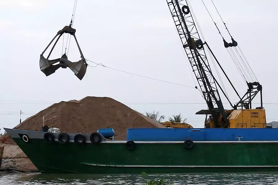 A crane moves sand from a ship on Mekong river in Hau Giang province, Vietnam on December 19, 2018.