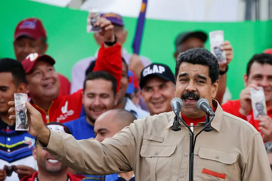 Venezuela's President Nicolas Maduro holds up a mock 100-bolivar bill depicting the president of the National Assembly Henry Ramos Allup, during a pro-government rally in Caracas, Venezuela December 17, 2016. 