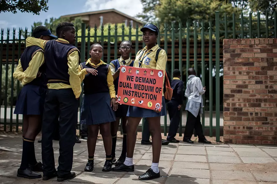 Students from surrounding schools and other stakeholders hold a cardboard as they march against the language and admission policies at Ho?erskool Overvaal school on January 25, 2018, in Vereeniging, South Africa.