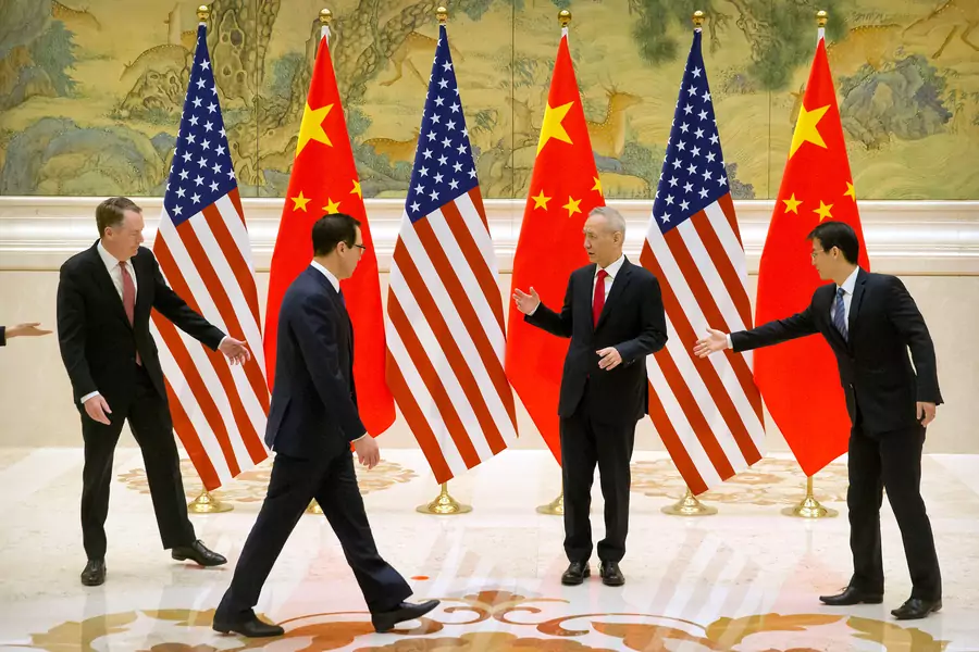 Aides gesture as U.S. Trade Representative Robert Lighthizer, Chinese Vice Premier and lead trade negotiator Liu He, and U.S. Treasury Secretary Steven Mnuchin line up for a photo before the opening session of trade negotiations at the Diaoyutai State Gue