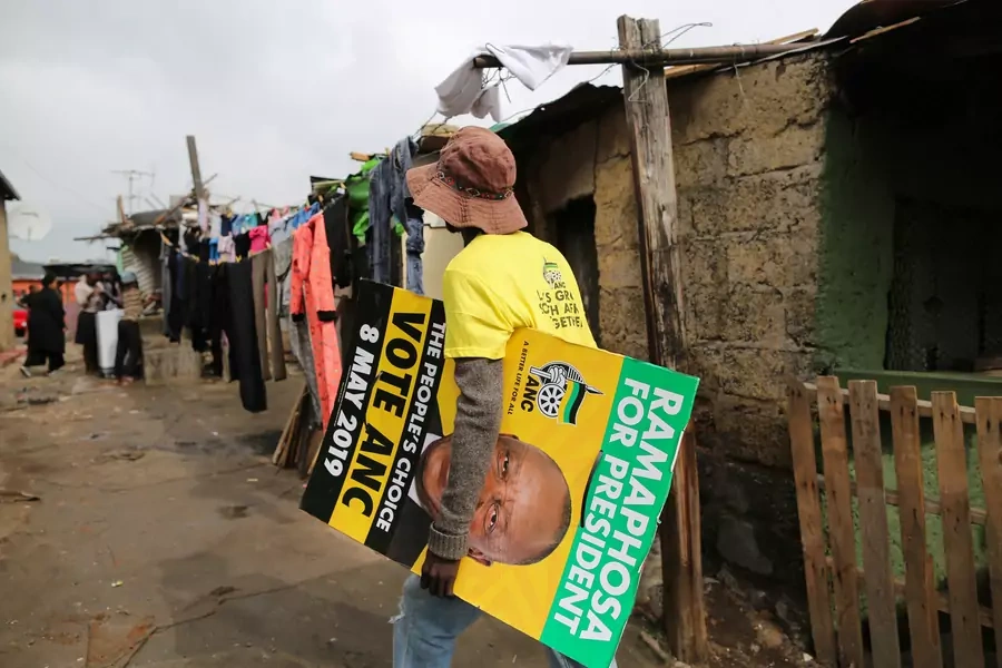 A man carries an election poster of the ruling African National Congress (ANC) through Alexandra township in Johannesburg, South Africa, on April 11, 2019.