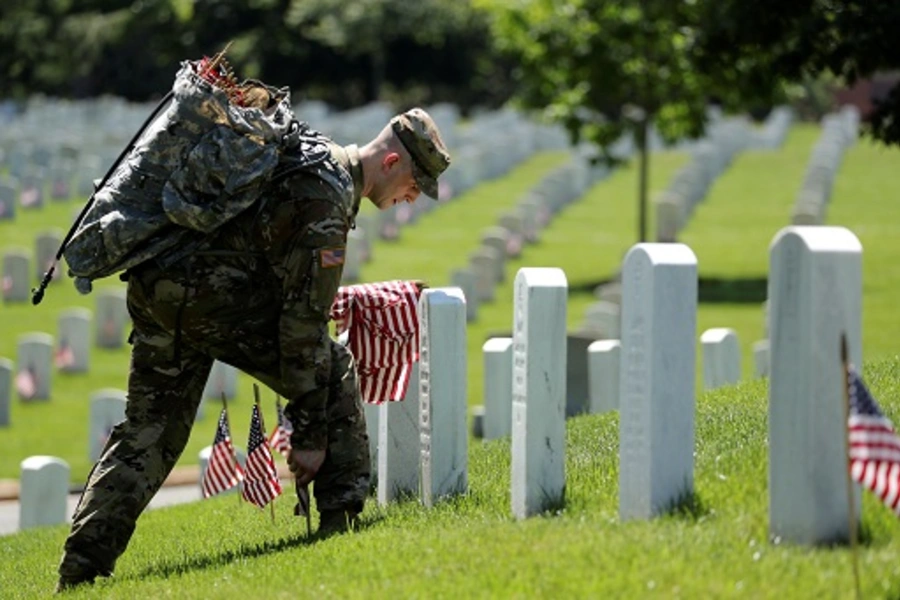 U.S. Army soldiers of the 3rd United States Infantry Regiment place U.S. flags on graves at Arlington National Cemetery, U.S. May 24, 2018. 