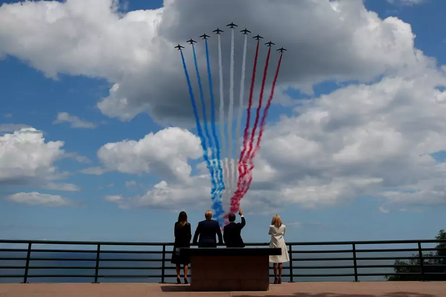 U.S President Donald J. Trump, First Lady Melania Trump, French President Emmanuel Macron, and his wife Brigitte Macron look to flypasts to commemorate the 75th anniversary of the D-Day landings in Normandy, France, June 6, 2019.