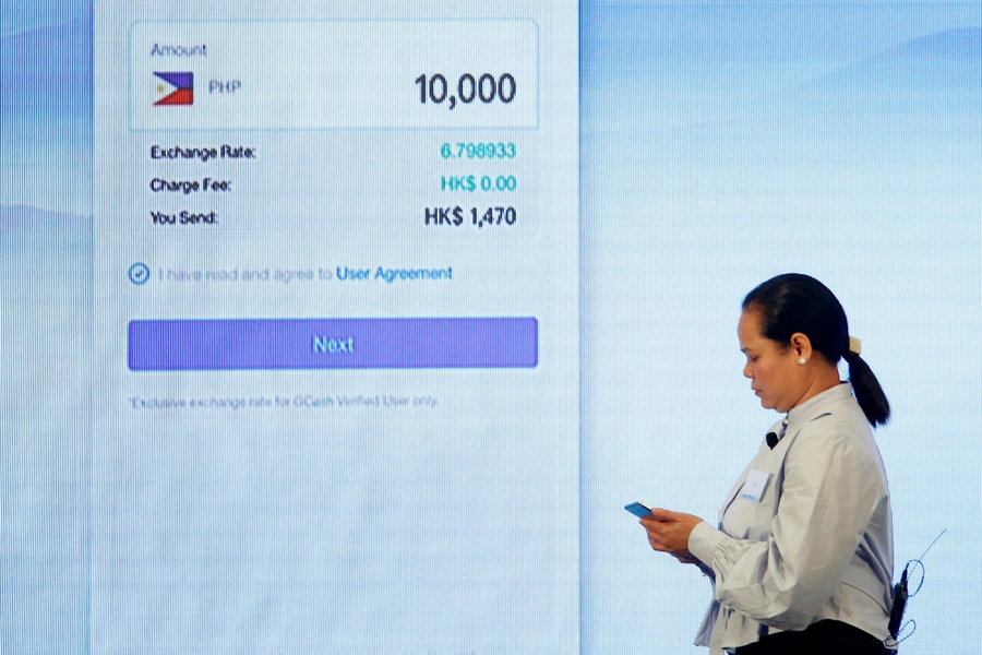 A Filipino guest demonstrates a blockchain-based remittance solution between Hong Kong and the Philippines during a news conference in Hong Kong, China, June 25, 2018. 