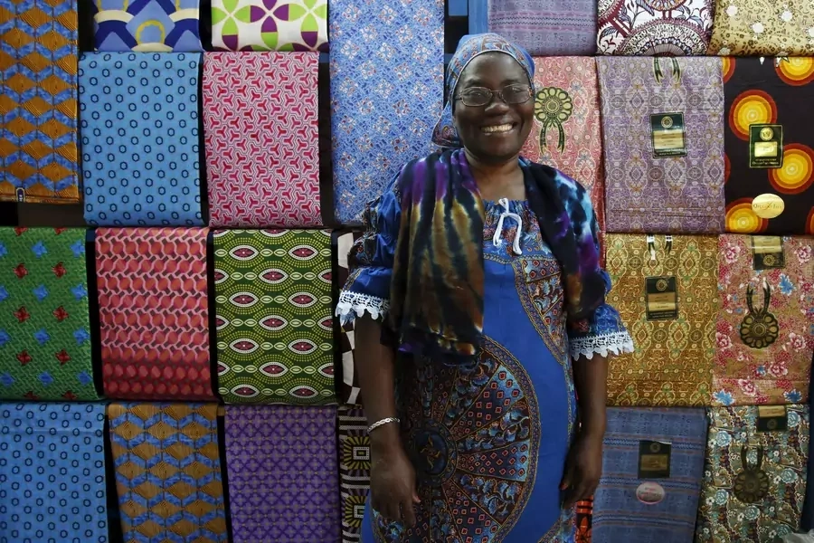 Fofanan Man, a 59-year-old businesswoman, poses for a photograph in front of textiles in her shop in Bouake, Ivory Coast.
