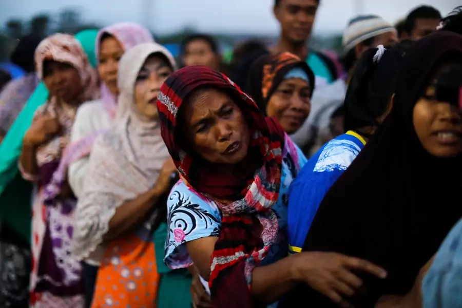 Women line up to received food at a camp for displaced victims of the earthquake and tsunami in Palu, Indonesia.