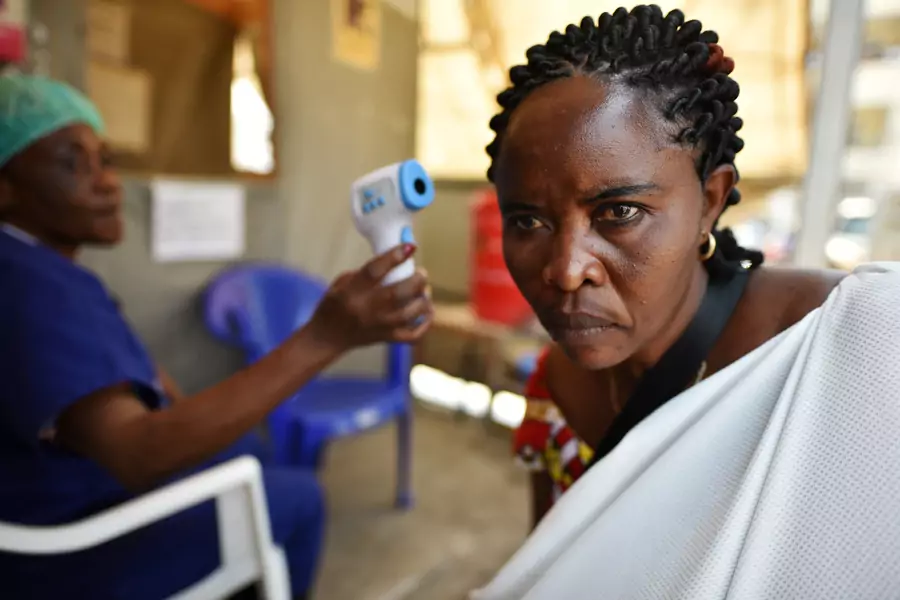 A health worker checks the temperature of a woman as part of the Ebola screening upon entering the General Hospital in Goma, Democratic Republic of Congo on July 15, 2019. 