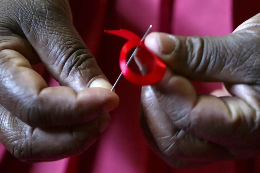 A Kenyan woman prepares a ribbon in honor of World AIDS Day in Nairobi, Kenya on November 25, 2004