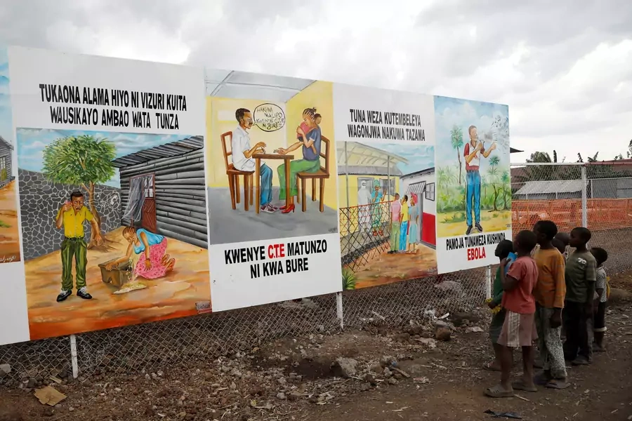Children look at a billboard providing information about Ebola outside the newly constructed MSF (Doctors Without Borders) Ebola treatment centre in Goma in Democratic Republic of Congo, August 3, 2019.