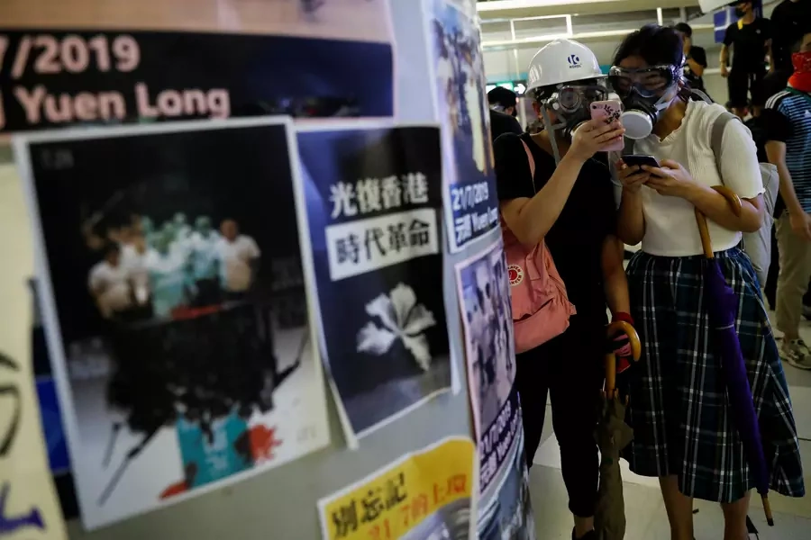 Protesters check their phones as they take part in a protest inside the Yuen Long MTR station. Hong Kong, China. August 21, 2019.