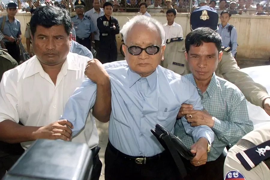 The Khmer Rouge's most senior surviving leader, “Brother Number Two” Nuon Chea, is held as he approaches the municipal court in the Cambodian capital Phnom Penh on December 13, 2002.