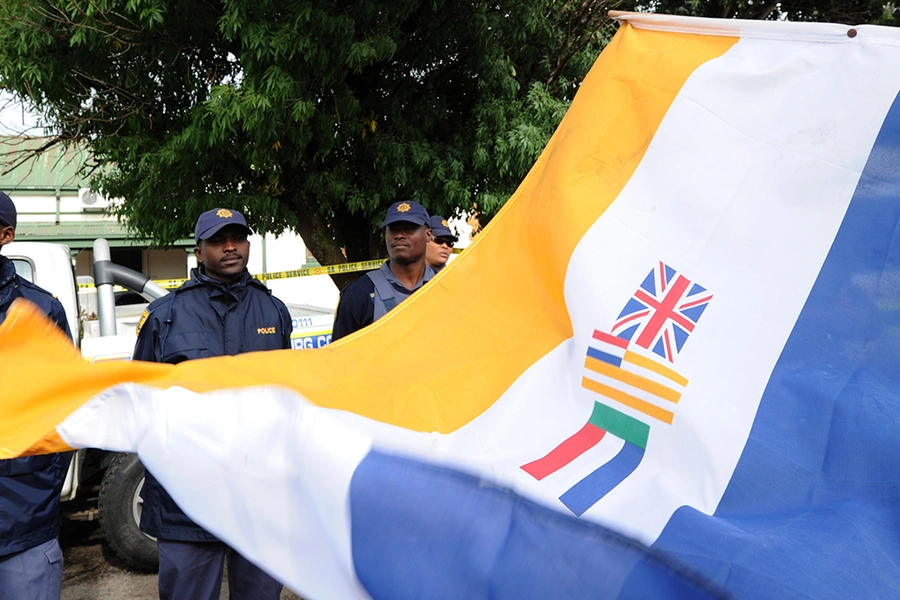 South Africans supporting the white supremacist Afrikaner Resistance Movement (AWB) fly the apartheid-era flag on April 6, 2010, outside a South African court in the northwestern town of Ventersdorp, South Africa.