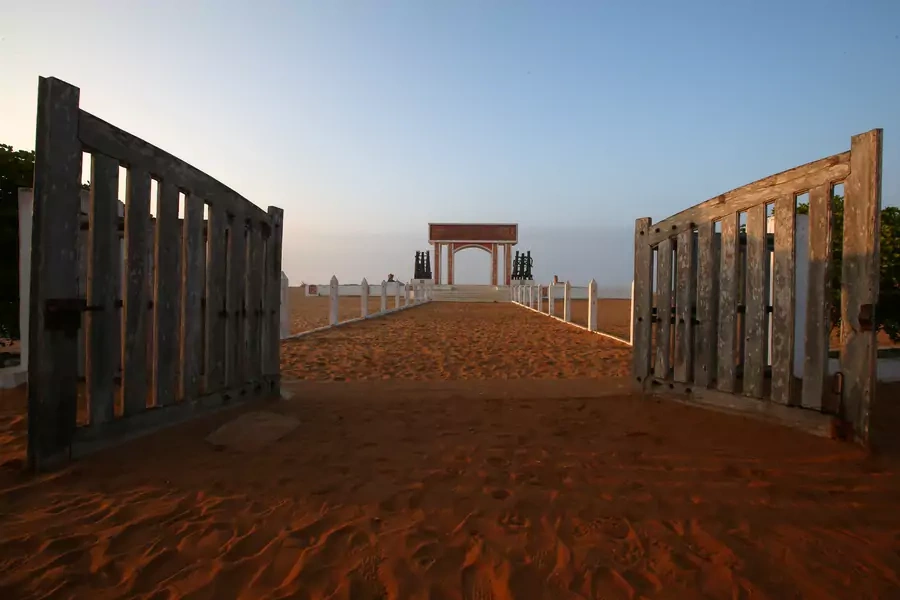 Open gates are seen before a monument at the site of the "Point of No Return" where slaves were loaded onto ships in the historic slave port of Ouidah, Benin, on July 17, 2019. 