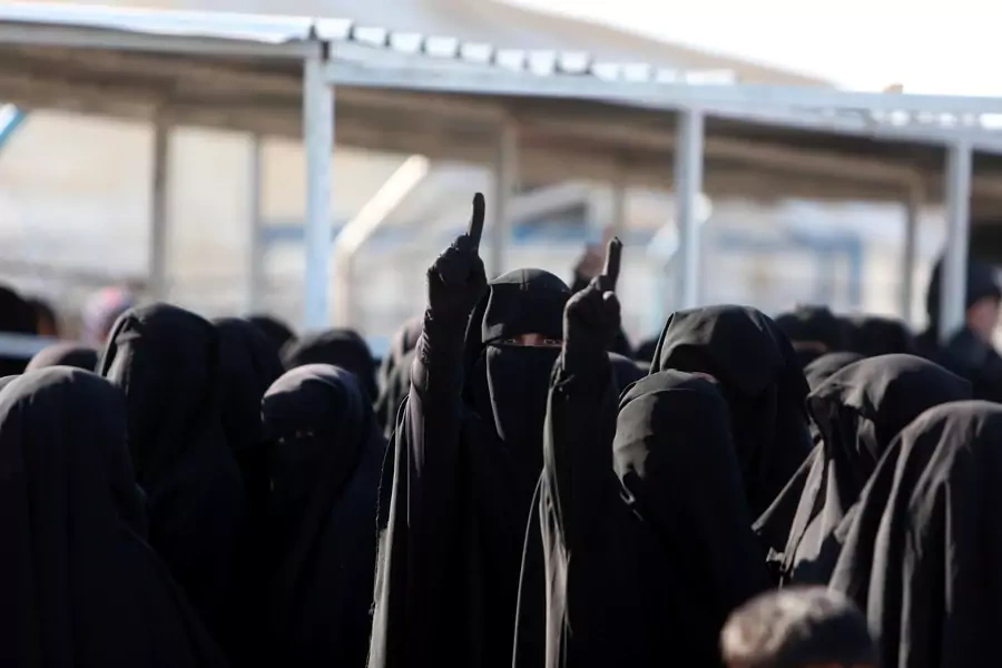 Women gesture as they stand together al-Hol displacement camp in Hasaka governorate, Syria, April 2, 2019.