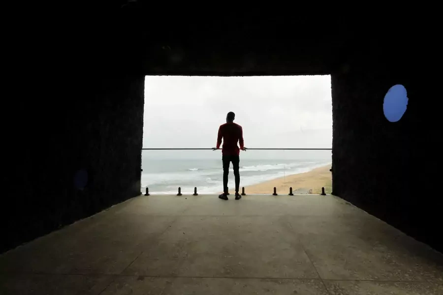 A man looks out at the sea from a building known locally as 'The Tunnel' located near the 'Point of No Return' where slaves were shipped from the slave port at Badagry, Nigeria, on August 20, 2019.