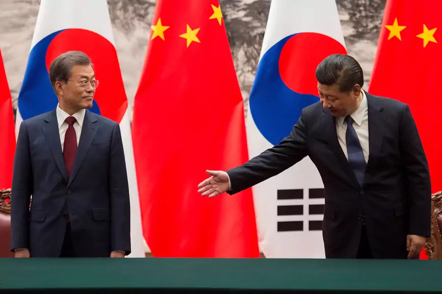 Chinese President Xi Jinping gestures toward South Korean President Moon Jae-in during a signing ceremony at the Great Hall of the People in Beijing, China on December 14, 2017.