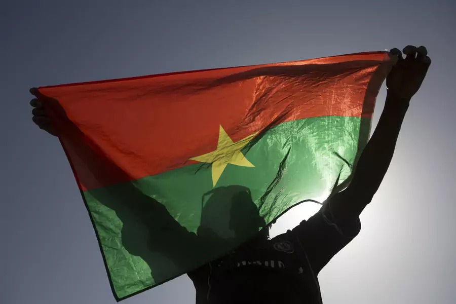 A pro-democracy protester holds up a Burkina Faso flag at Place de la Nation in Ouagadougou, capital of Burkina Faso, November 2, 2014
