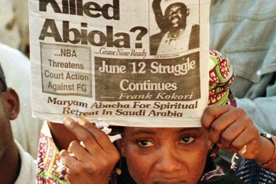 A supporter of Chief Mashood Abiola holds up a newpaper during a demonstration outside the family home to protest about the suspicious nature of his death, on July 10, 1998. 