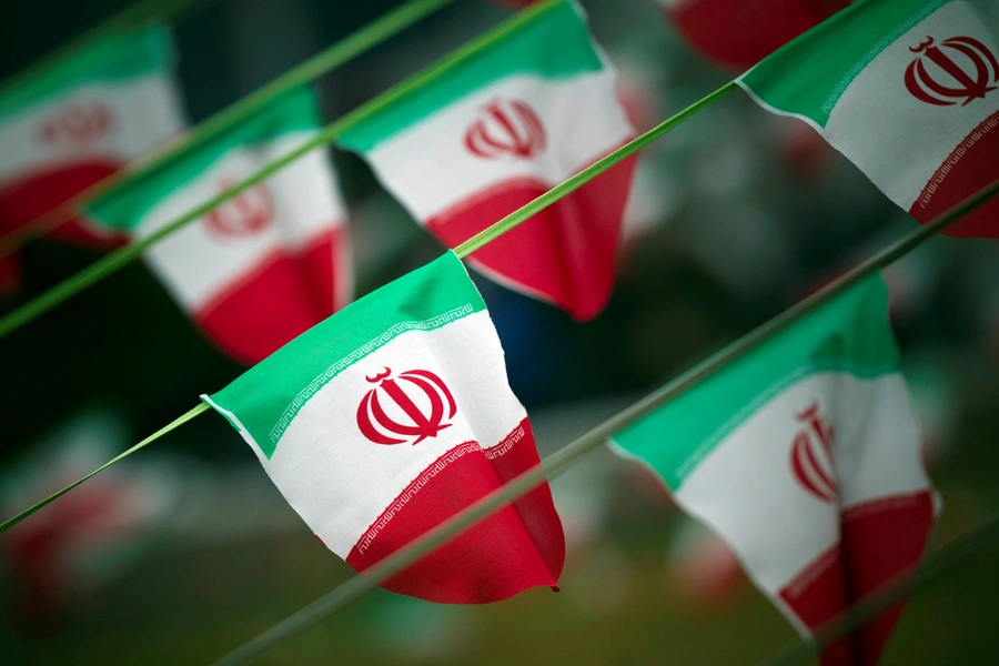 A line of Iranian flags wave in a square in Tehran. 