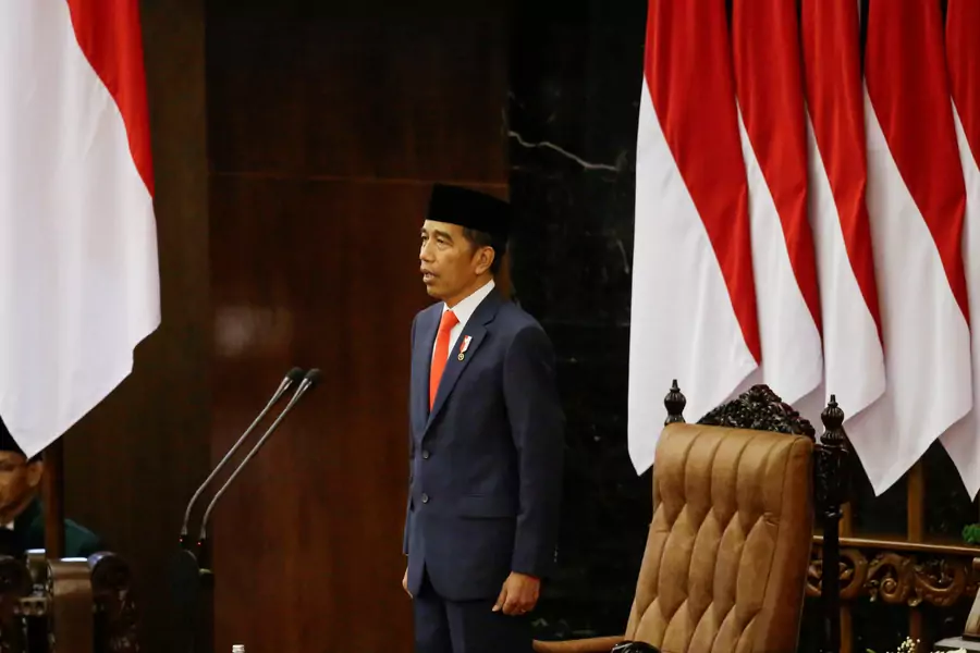 Indonesian President Joko Widodo stands as he listens to the national anthem after taking an oath during his presidential inauguration for the second term, at the House of Representatives building in Jakarta, Indonesia, on October 20, 2019.