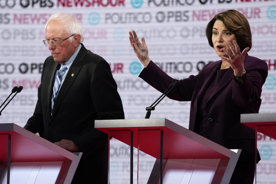 Senator Bernie Sanders listens to Senator Amy Klobuchar speak at the Democratic presidential debate on December 19. 