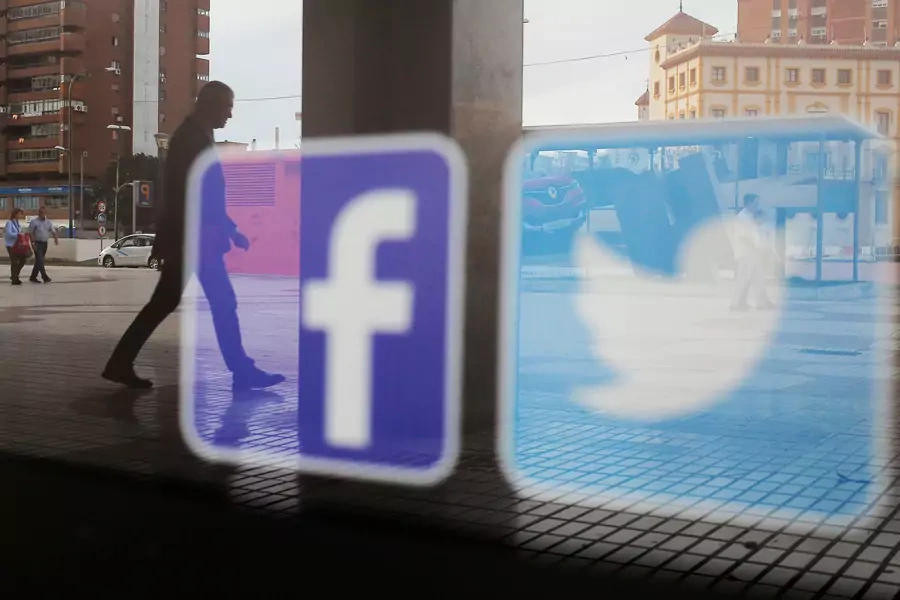 Facebook and Twitter logos are seen on a shop window in Malaga, Spain