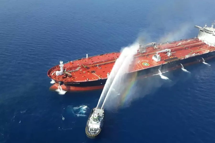 An Iranian navy boat tries to stop the fire of an oil tanker after it was attacked in the Gulf of Oman on June 13, 2019.