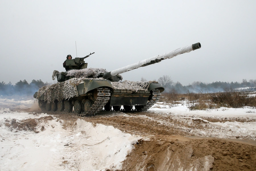 Ukrainian soldiers ride on top of a tank during military exercises in the Chernihiv region of Ukraine on December 3, 2018.