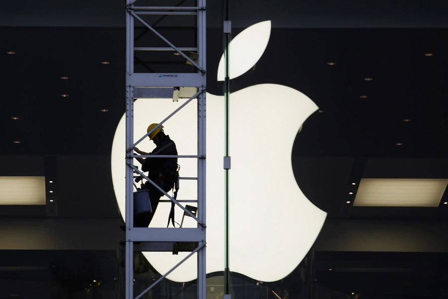 A worker climbs outside an Apple store in Hong Kong.