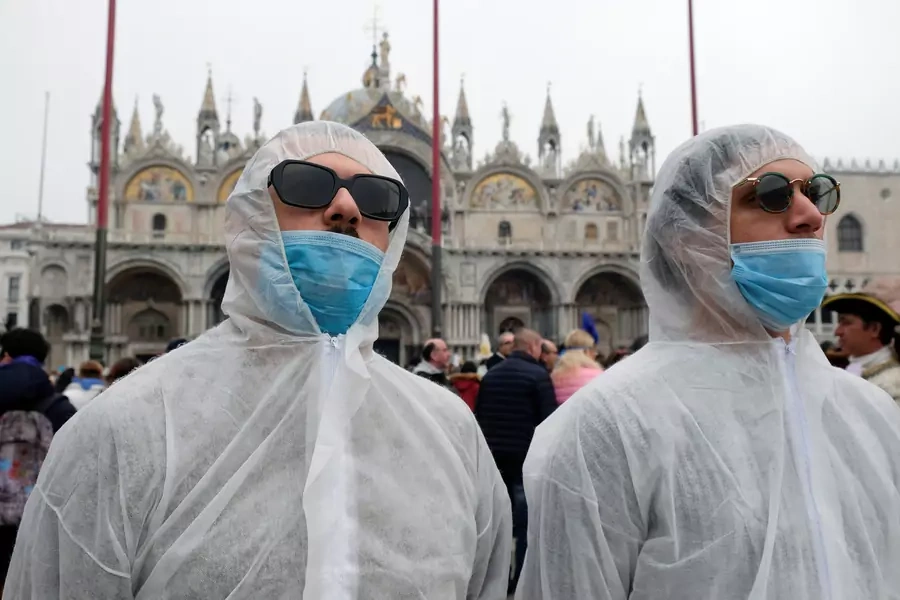 Tourists wear protective face masks at Venice Carnival, which has been cancelled because of an outbreak of coronavirus, in Venice, Italy on February 23, 2020. 