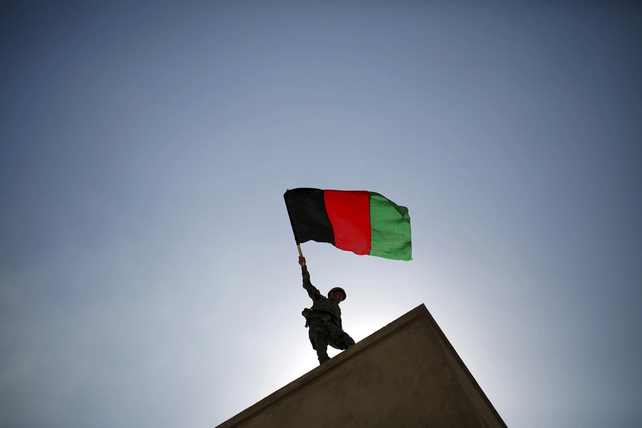 An Afghan National Army officer holds the Afghan flag during a training exercise in Kabul in October 2015.