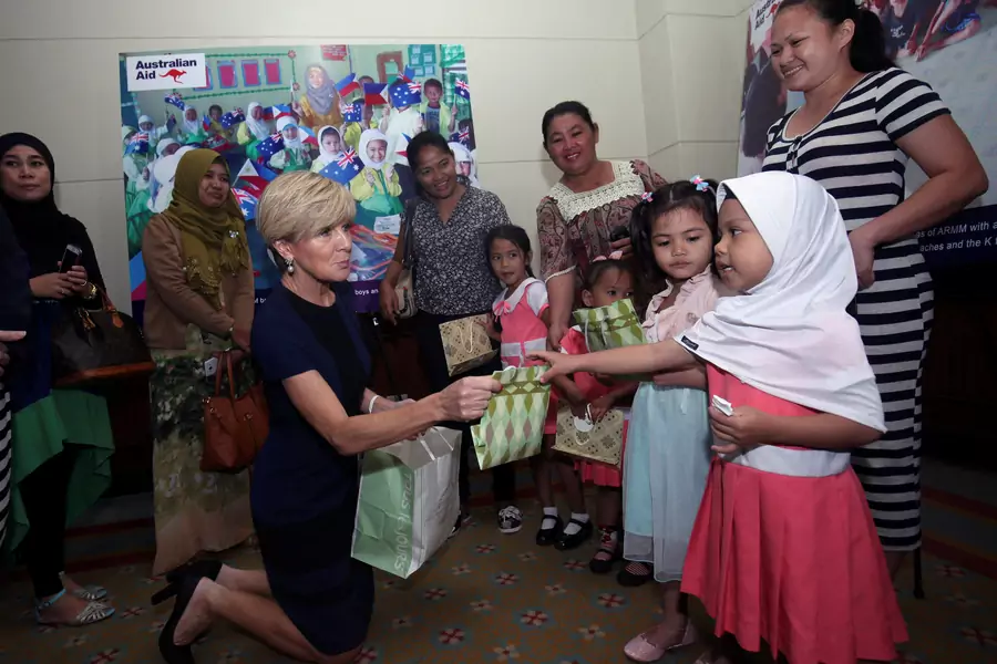 Australian Foreign Affairs Minister Julie Bishop hands over a gift to girls from the Autonomous Region of Muslim Mindanao (ARMM) during a visit in Davao city, Philippines.
