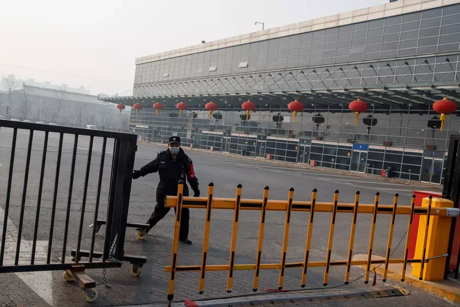 A security guard closes a gate at the Sihui Long Distance Bus Station in Beijing after the city has stoped inter-province buses services as the country is hit by an outbreak of the new coronavirus, January 26, 2020.